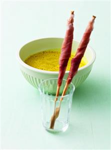 Curried courgette soup, grissini wrapped in prosciutto