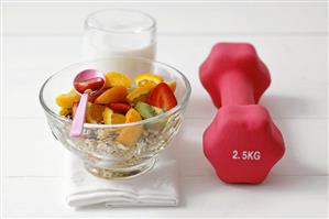 Muesli with fresh fruit, milk and hand weight