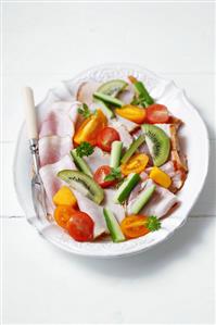 Ham platter garnished with fruit and vegetables