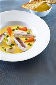 Creamy fish soup with aioli and bread chip