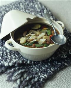 Vegetable soup with noodles and Parmesan in soup bowl