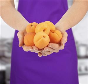 Hands holding fresh apricots