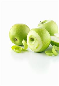 Green apples, one partly peeled