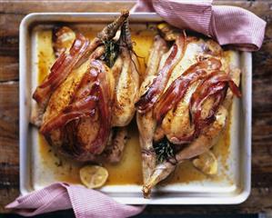 Roast chickens with date stuffing and slices of bacon