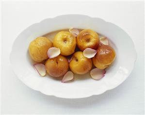 Poached peaches with orange syrup and rose petals