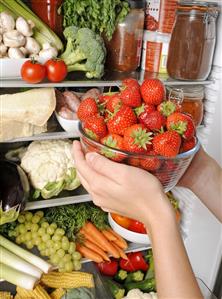 Taking a bowl of strawberries out of a refrigerator