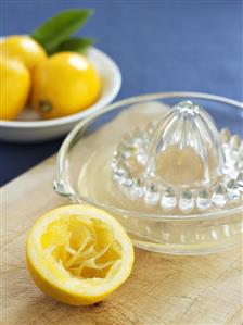 Squeezed lemon half with lemon squeezer and lemon juice