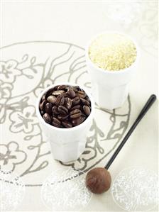 Beaker of coffee beans & beaker of sugar with a chocolate