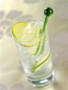 A glass of gin and tonic with slices of lime