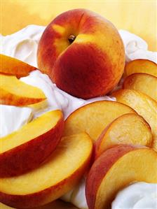 Whole peach and peach slices on cream