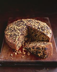 Chocolate hazelnut cake, pieces removed, on wooden board