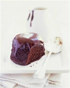 Individual chocolate pudding with chocolate sauce & a spoon