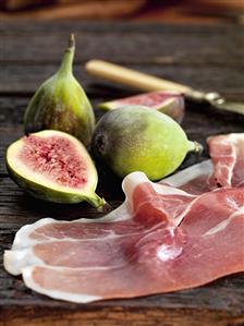 Fresh figs and Parma ham on wooden background