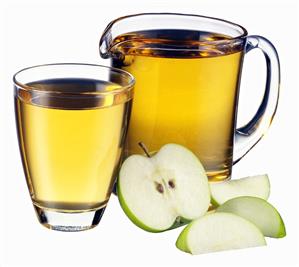 Apple juice in jug and glass and pieces of apple