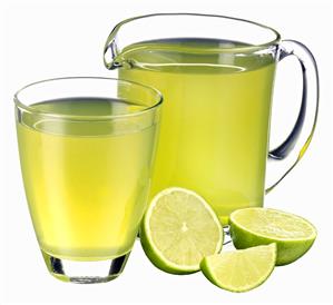 Lime juice in jug and glass and fresh limes