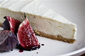 A piece of vanilla cheesecake with figs