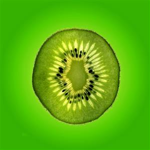 Slice of kiwi fruit against green background