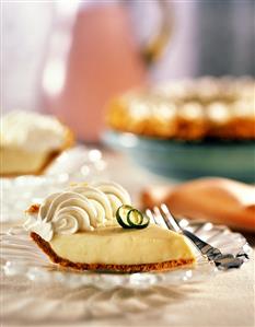 Key Lime Pie Slice with Whole Pie in Background