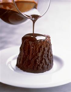 Pouring Chocolate Sauce over Chocolate Pudding