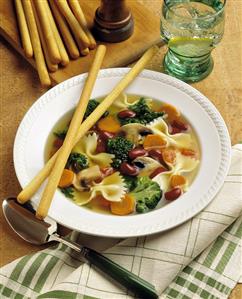 A Bowl of Vegetable Soup with Farfalle; Grissini