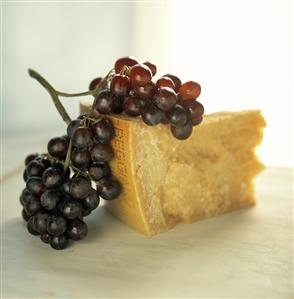 Piece of parmesan with purple grapes