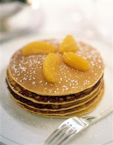 A Stack of Pancakes with Orange Slices