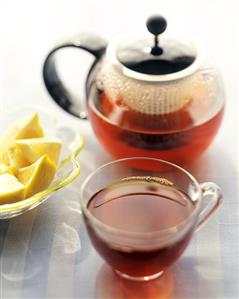 Tea in glass cup and pot and wedge of lemon