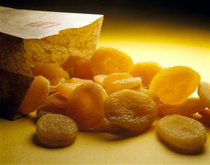 Dried apricots in front of paper bag