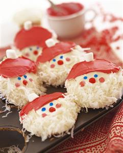 White chocolate coconut biscuits decorated as Father Christmases