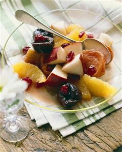 Bowl of Fruit Salad with a Spoon on a Dish Cloth