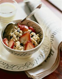 Bowl of Oatmeal with Raisins and Fresh Strawberries; Spoon