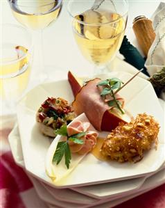 Appetizer Plate with Four Assorted Hors d'oeuvres; Glasses of White Wine