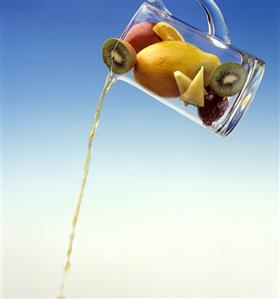 Pouring Juice out of a Pitcher with Fresh Fruits