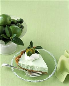 Piece of lime pie with cream and lime slices