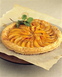 Freshly baked peach tart with sprig of mint (1)