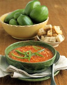 Red pepper soup with strips of green pepper; croutons