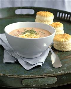 Cream of tomato soup with strips of cheese; biscuits