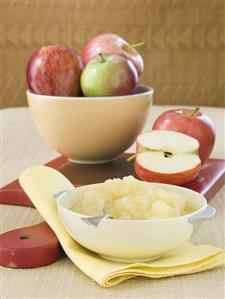 Bowl of Homemade Applesauce with a Bowlful Fresh Apples; Cutting Board