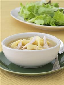 Bowl of Chicken Noodle Soup; Side Salad in Background