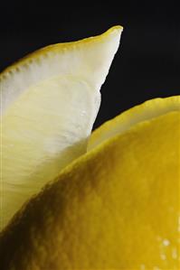 Close Up of Lemon Slice with Lemon on a Black Background