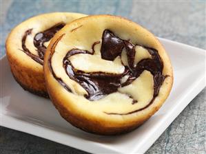 Two Mini Orange Chocolate Swirl Cheesecakes on a Plate; Close Up