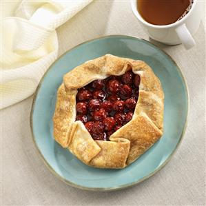 Rustic Cherry Pastry on a Blue Plate; Cup of Tea