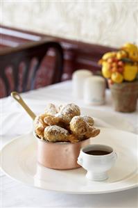 Fritters in copper pan with dip on restaurant table