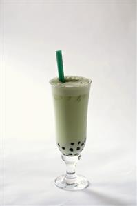 Blueberry milkshake in glass against white background