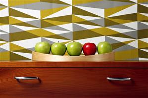 Four green apples & one red apple on drawers, coloured wallpaper