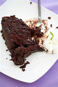 Partially Eaten Slice of Chocolate Layer Cake on a Plate