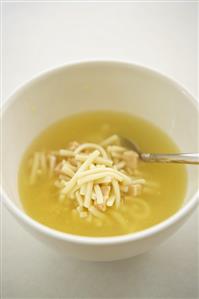 Chicken Noodle Soup in a White Bowl with a Spoon