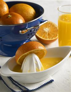 Oranges in Colander, Orange Half on Juicer, Glass of Orange Juice