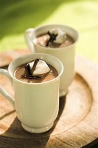 Two Mugs of Hot Chocolate with Whipped Cream and Chocolate Curls