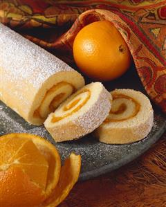 Rolled Orange Sponge Cake Sliced on a Platter